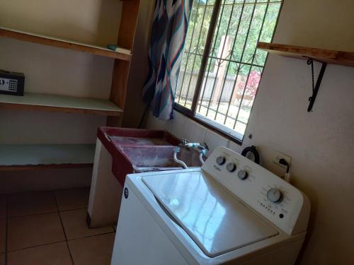 a kitchen with a washing machine and a sink at Cahuita Lodge in Cahuita