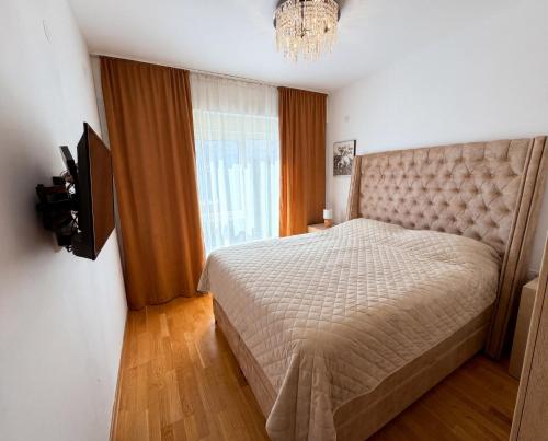 a bedroom with a bed and a television in it at Status S in Bečići