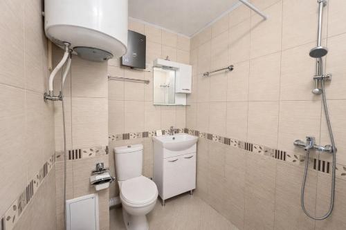 a bathroom with a toilet and a sink and a shower at Къщата с чешмата in Veliko Tŭrnovo