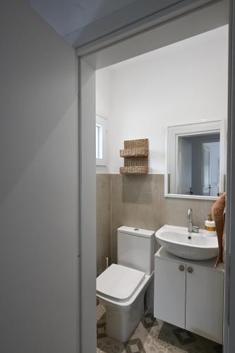 a bathroom with a white toilet and a sink at Palataki in Epanomi