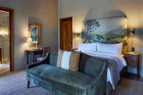 a bedroom with a large bed and a couch at Blaauwklippen Manor by NEWMARK in Stellenbosch