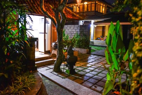 a house with a tree in the middle of a courtyard at Griya Sriwedari in Ubud