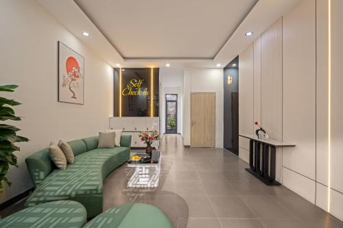 a living room with a green couch and a fireplace at Hanami Residence - Self Check-in Accommodation in Danang