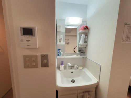 a bathroom with a sink and a mirror at Lucky民泊 in Osaka