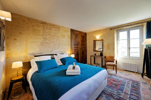 a bedroom with a large bed with blue pillows at Les Hauts de Saint Vincent B&B proche Sarlat in Saint-Vincent-de-Cosse
