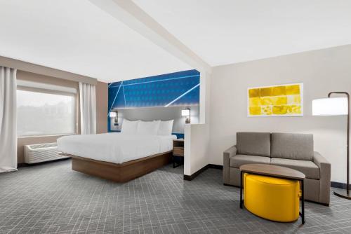 a large hotel room with a bed and a couch at Comfort Inn & Suites Suwanee - Sugarloaf in Suwanee