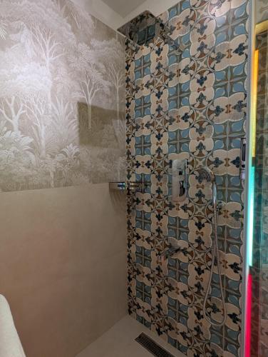 a shower in a bathroom with a tiled wall at Clouthy Villa in Cochin