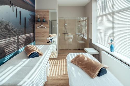 a bathroom with two beds and a bath tub at aja Grömitz in Grömitz