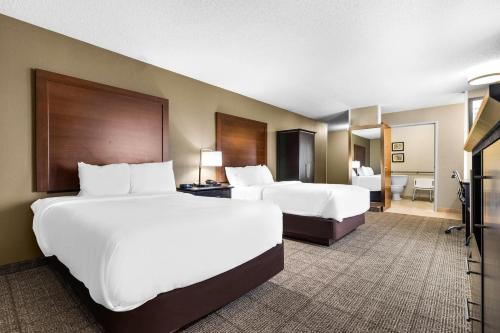 a hotel room with two beds and a television at Comfort Inn Evansville East in Evansville