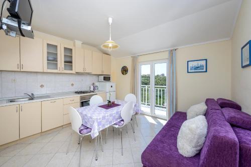 a kitchen with a purple couch and a table at Villa Bingo in Cavtat