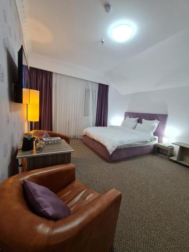 a hotel room with a bed and a couch at Casa cu pastravi in Sinaia