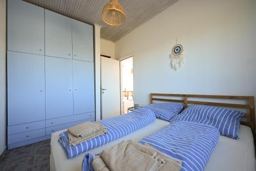 a bedroom with two beds with blue and white stripes at Summer house Spiti Pirgos in Epanomi