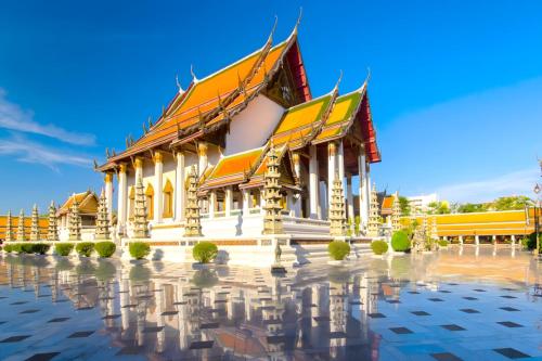 a building with a reflection in the water at AT Pranakorn Khaosan - Samsen Soi 2 in Bang Bua Thong Railway Station
