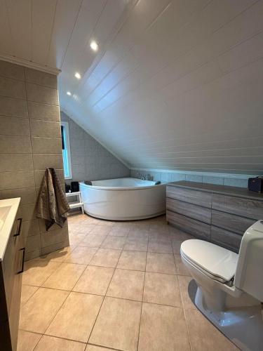 a large bathroom with a tub and a toilet at Big villa with outbuilding in Sarpsborg