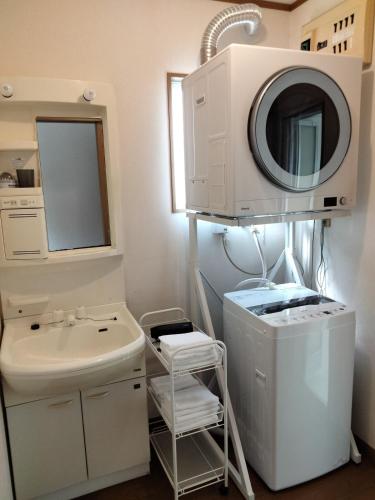 a bathroom with a sink and a mirror at Sakura Inn in Chiba