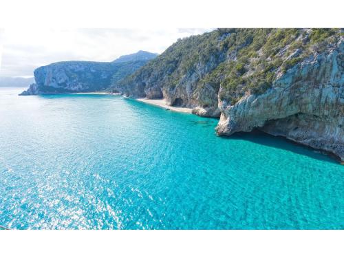 an aerial view of a beach next to a cliff at I Ginepri Hotel in Cala Gonone
