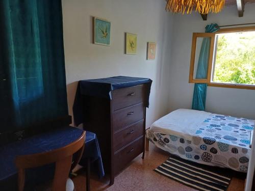 a bedroom with a dresser and a bed and a window at Houpla Sol in Manacor