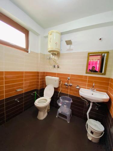 a bathroom with a toilet and a sink at Non Stop Cafe Hostel & Stay in Manāli