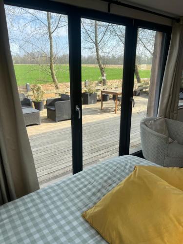 a bedroom with a bed and a view of a deck at L Antre Vous in Mons