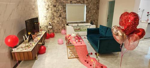 a living room with red balloons and a blue couch at روز بيلا 1 Rosa Bella in Al Jināh