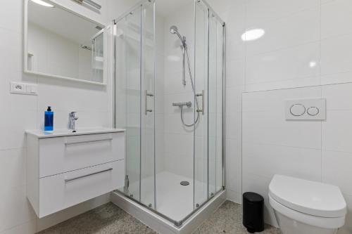 a white bathroom with a shower and a toilet at LAM Schon - AC in Bratislava