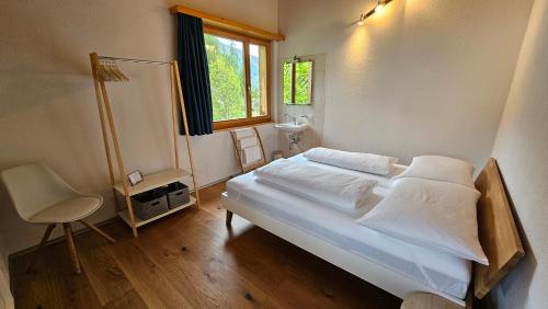 a bedroom with a bed and a sink and a window at Gruppenhaus Grächbiel in Grächen