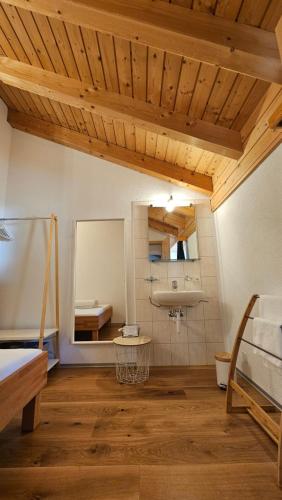 a room with a bed and a mirror and wooden ceilings at Gruppenhaus Grächbiel in Grächen
