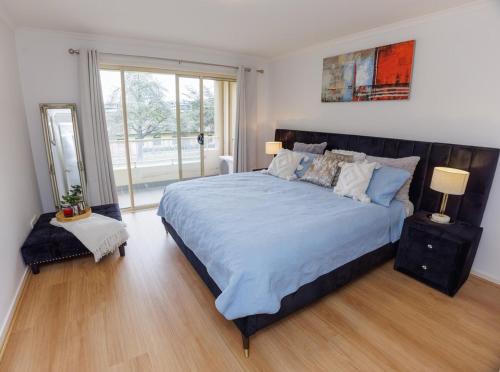 a bedroom with a large bed and a window at Stylish inner-city Haven in Braddon