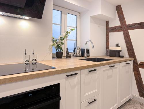 a kitchen with white cabinets and a sink and a window at Maison Alsacienne 4Ch & Suite Parentale sur la Route des Vins in Marlenheim