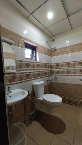 a bathroom with a toilet and a sink at Masterkey stay in Kakkanad
