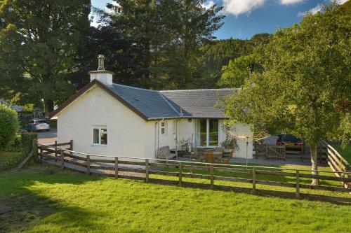 a white house with a fence in front of it at Melfort Village in Oban
