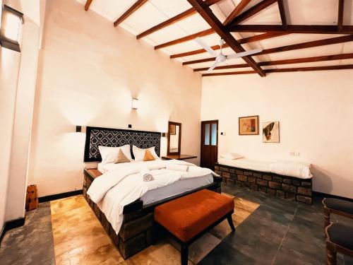 a large bedroom with a large bed and a bench at Shvaas Boutique Villa in Dambawelagama