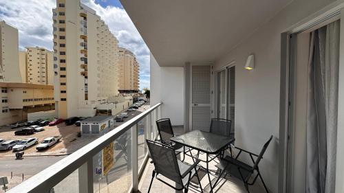 a balcony with chairs and a table on a balcony at Elite 3F Portimão com mar, piscina e garagem in Portimão