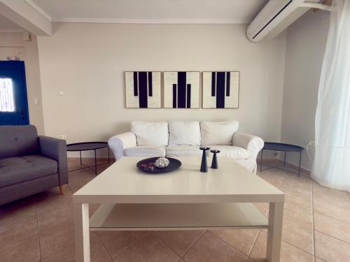 a living room with a white table and a couch at Remvi Beachfront Suites by Horizon Homes in Orfánion