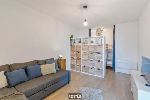 a living room with a couch and a book shelf at Sandy View - spacious studio flat near the beach in Nieuwpoort