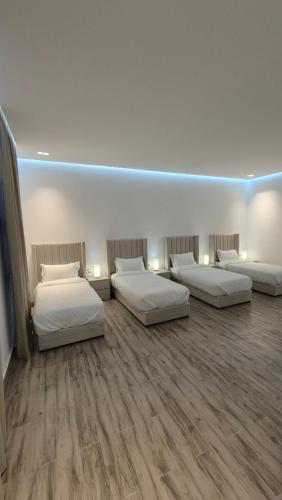 three beds in a room with wooden floors at Noor-Hatta Deluxe Villa Farmhouse in Hatta