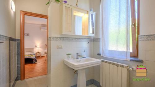 a white bathroom with a sink and a window at In Vino Veritas B&B in Arcola