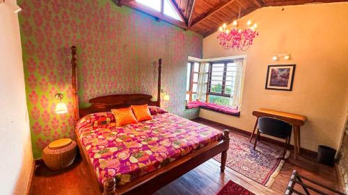 a bedroom with a bed and a table and a window at Natural Elements by Levitate - Premium Two Room Chalet with Private Terrace Panoramic Forest View & Dedicated Kitchen in Rāmgarh
