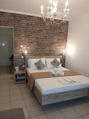 a bedroom with two beds and a brick wall at Melirito in Olympiada