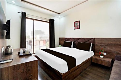 a bedroom with a large bed and a window at GREAT ROYAL eMPIRE in Tājganj