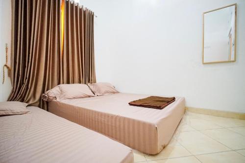 two beds sitting next to each other in a room at Rayyan Homestay Jogja in Timuran