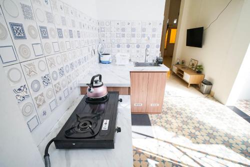 a kitchen with a stove with a tea kettle on it at Rayyan Homestay Jogja in Timuran