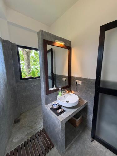 a bathroom with a sink and a mirror at Lara's place in Unawatuna
