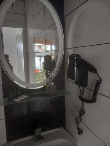 a bathroom with a sink with a mirror and a hair dryer at Melirito in Olympiada