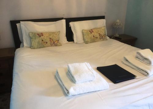 a white bed with towels and books on it at The Black Dog Inn in Broadmayne