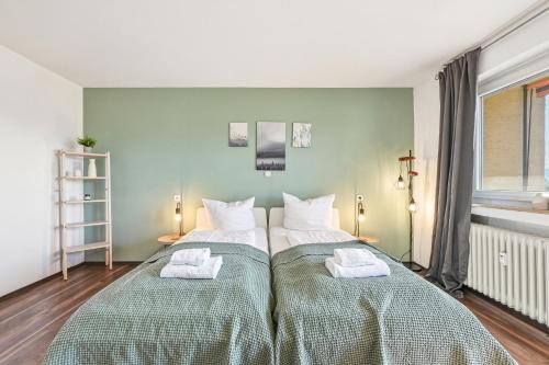 a bedroom with two beds with towels on them at Salí Homes Weinblick Beethoven - ruhige Feldlage in Obersulm