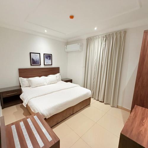 a bedroom with a large bed and a window at عوالي للشقق المخدومة Awali Serviced Apartments in Al Khobar