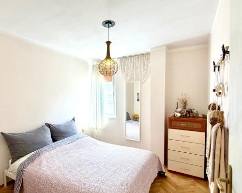 a bedroom with a bed and a chandelier at Joy Home Varna in Varna City
