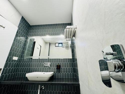 a black and white bathroom with a sink and a mirror at HOTEL SUNIL INN in Raipur