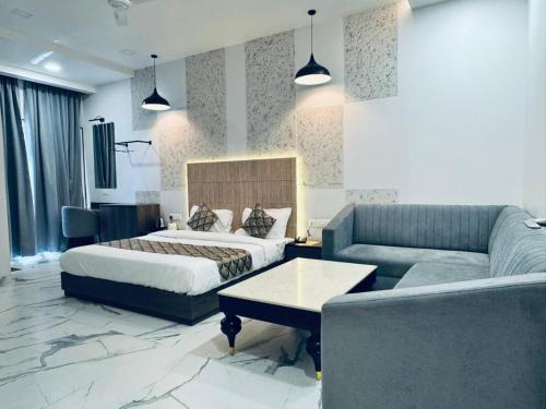 a hotel room with a bed and a couch at HOTEL SUNIL INN in Raipur